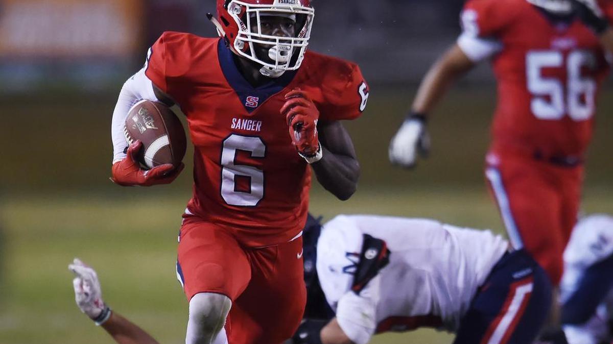 Sanger’s Kosi Agina, center, runs down the sidelines for a touchdown against San Joaquin Memorial Friday, Nov. 1, 2019 in Sanger.