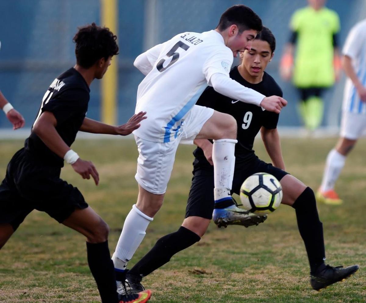Clovis High’s Oscar Rubalcava, left, and Carlos Osuna, background, attack Clovis North’s Sam Jazo, center, in a matchup at Clovis High Tuesday, Jan. 30, 2018 in Clovis. Clovis High won 2-1.