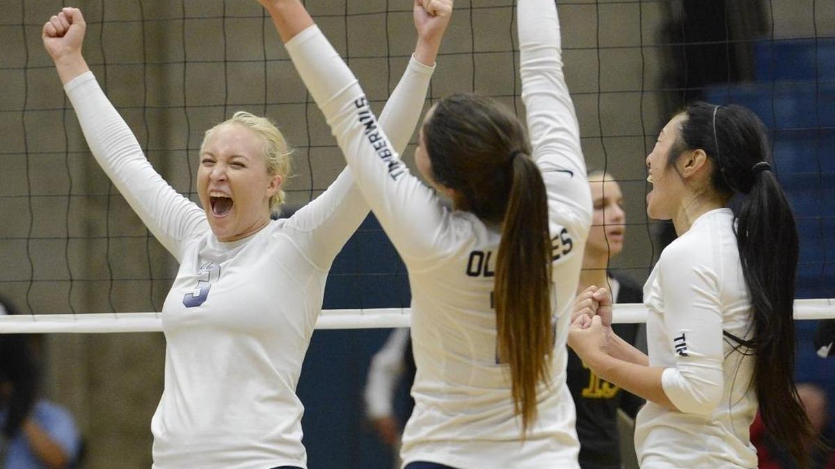 Clovis East’s Abby Edwards, from left, Brittany Olivares and Christina Tran celebrate winning the second set against Clovis West. The Timberwolves went on to defeat the Golden Eagles 25-23, 25-12, 20-25, 25-22 to clinch at least a share of the school’s first Tri-River Athletic Conference volleyball title.