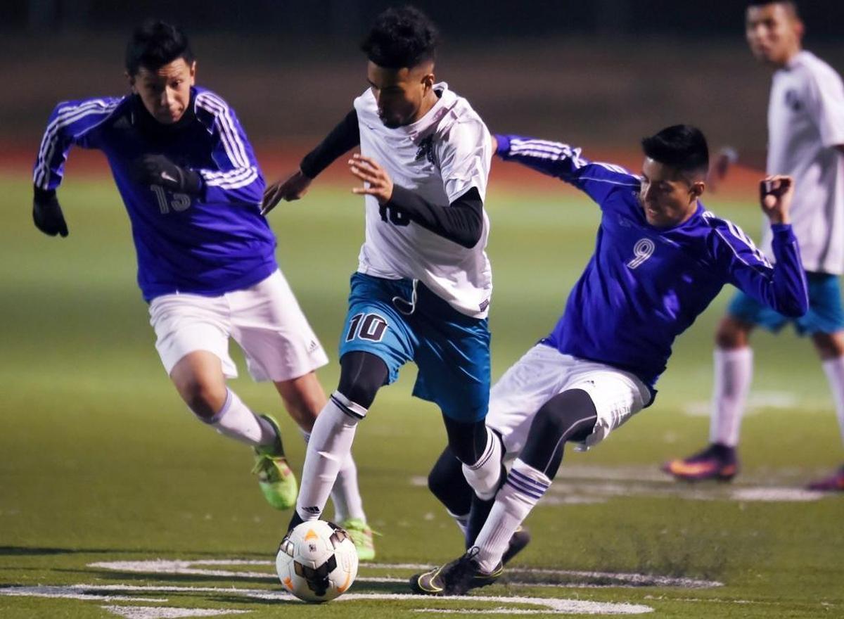 Mendota’s Danny Trejo, center, charges between Avenal’s Francisco Rosario, left, and Gerardo Calata, right, in a matchup Tuesday, Jan. 17, 2017 in Mendota, Calif. Mendota is the top seed for the CIF Southern California Regional Division V playoffs and will host No. 8 La Cañada in an opening-round match Tuesday, March 7, 2017.