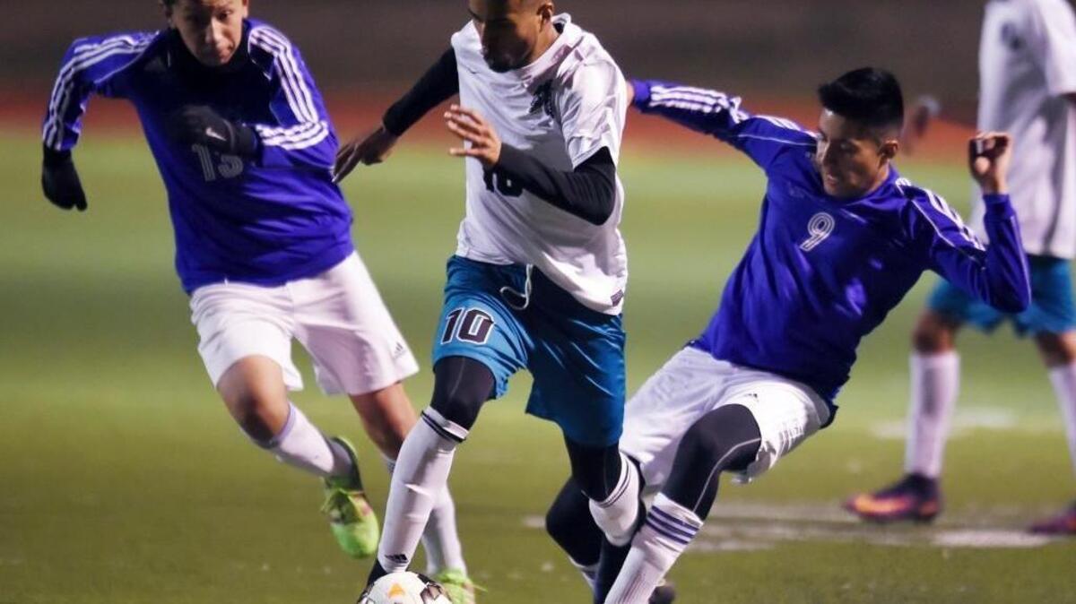 Mendota’s Danny Trejo, center, charges between Avenal’s Francisco Rosario, left, and Gerardo Calata, right, in a matchup Tuesday, Jan. 17, 2017 in Mendota, Calif. Mendota is the top seed for the CIF Southern California Regional Division V playoffs and will host No. 8 La Cañada in an opening-round match Tuesday, March 7, 2017.