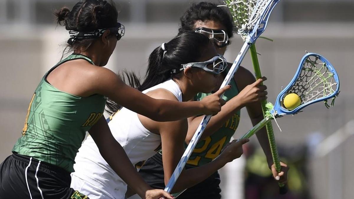 Sunnyside High’s Xayaphone Salinthone drives between Roosevelt’s Gracielita Bastidas, left, and Ruby Olea in Thursday’s Fresno Unified Lacrosse Tournament match. Salinthone scored six goals as the fourth-seeded Wildcats beat the No. 5 Rough Riders 11-6.