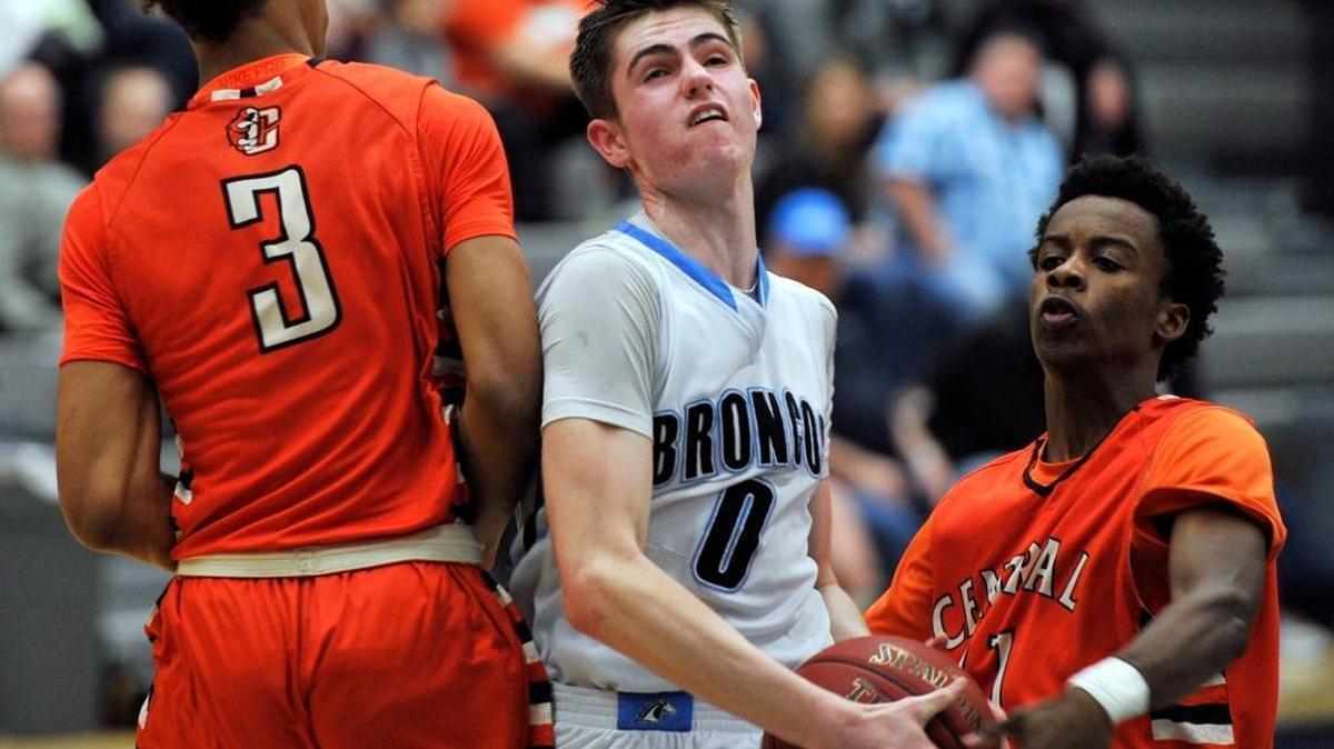 Clovis North’s Ben Avera, driving against Central’s Eddie Mcfall, right, and Cam’ron Wilson, on Feb. 12, 2016, helped power the Broncos to a No. 1 seed in the Central Section Division I playoffs. Central is No. 2.