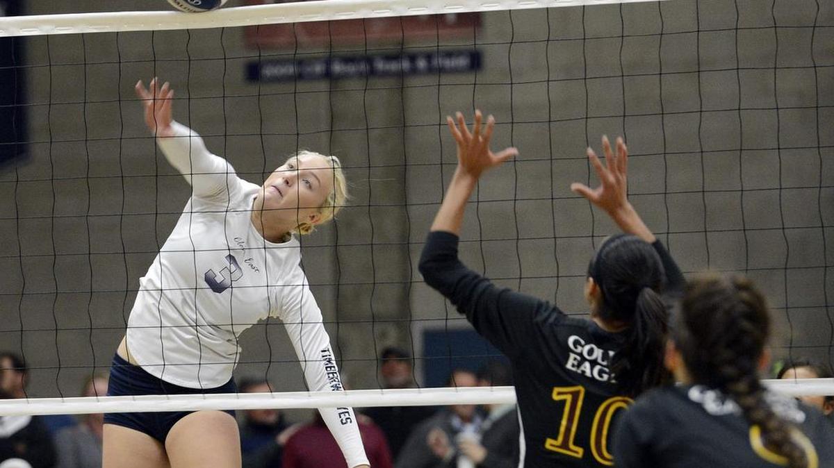 Clovis East’s Abby Edwards, left, tips the ball over the net for a point against Clovis West in their match at Clovis East Tuesday, Nov. 3, 2015. Clovis East won to clinch at least a tie for the TRAC title with one match remaining.