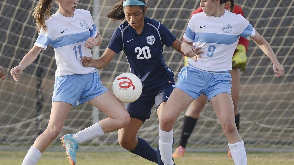 Bullard’s Alyssa Renovato, center, works the ball between Clovis North’s Courtney Prince, left, and Natalie Nurcanyan during their non-league Central Section girls soccer match at Clovis North Tuesday, Dec. 8, 2015. Clovis North won 2-0.