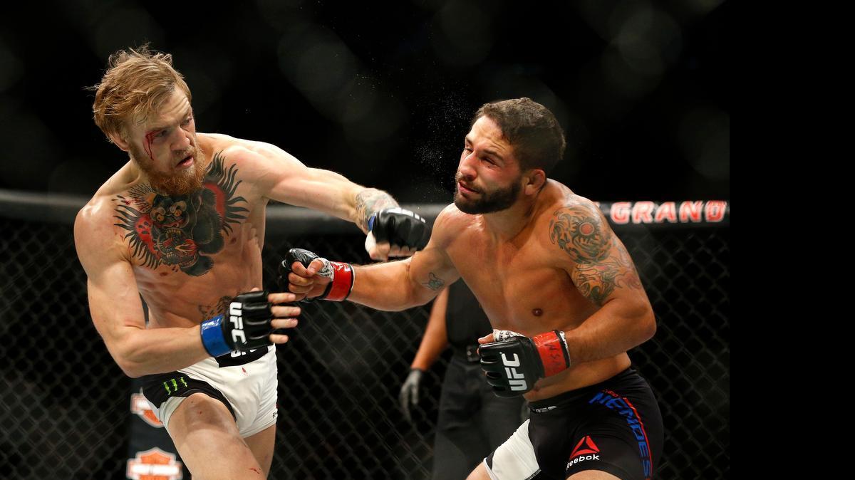 
Conor McGregor punches Chad Mendes during their interim featherweight title mixed martial arts bout at UFC 189 on July 11, 2015, in Las Vegas.
