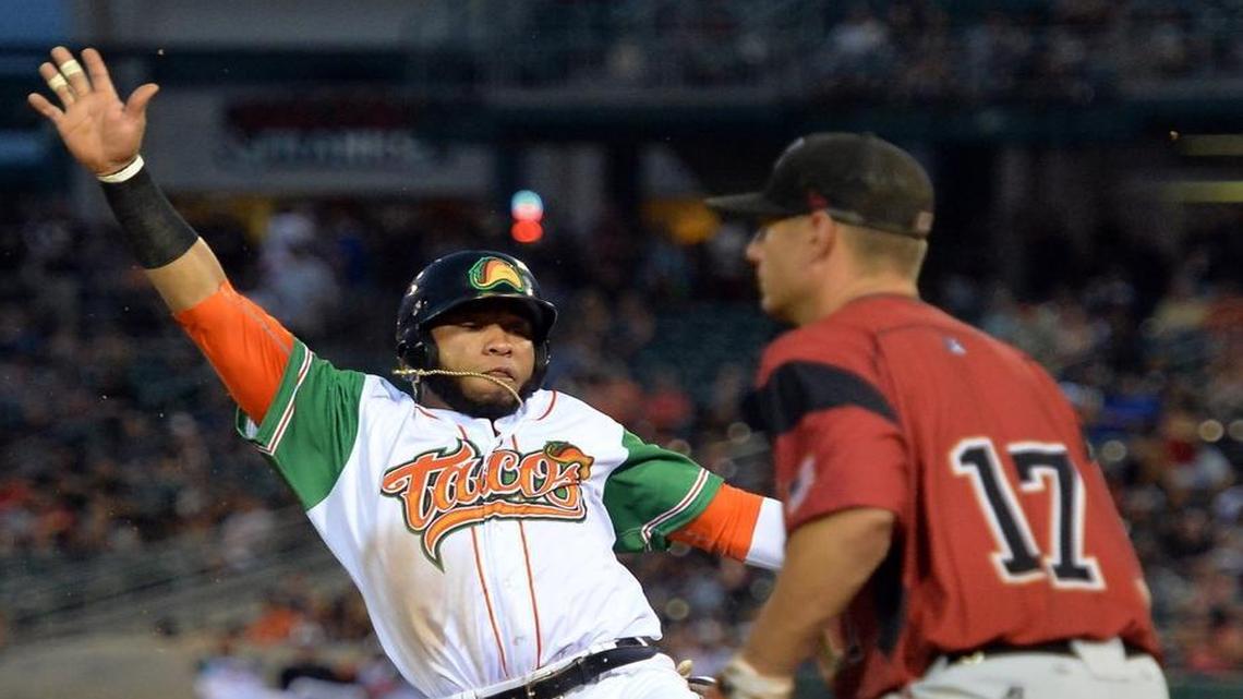 
Fresno’s Jon Singleton, wearing the Grizzlies’ Tacos-themed jersey as part of the annual Taco Truck Throwdown promotion, slides in during an Aug. 6, 2015, game against Sacramento at Chukchansi Park. 
