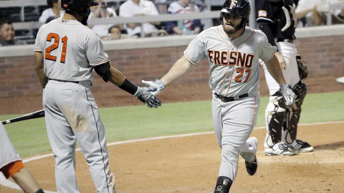 
Fresno’s Tyler White, right, celebrates his solo home run with teammate Jon Singleton on Saturday against the El Paso Chihuahuas. Fresno won 7-4 to clinch the best-of-five series 3-1.
