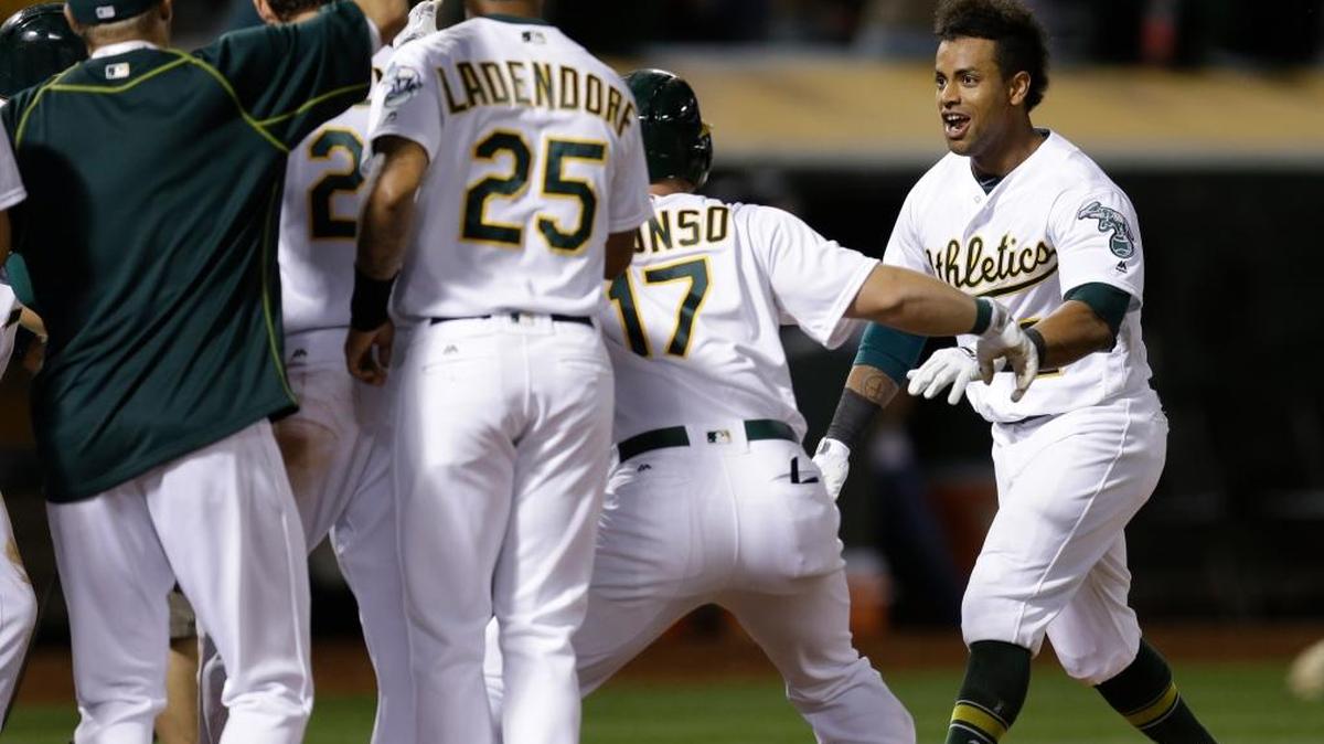 Khris Davis, right, and his A’s teammates celebrate his walkoff grand slam on Tuesday night in Oakland