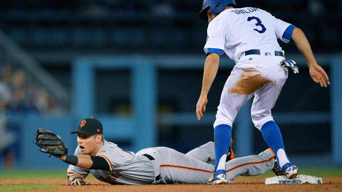Los Angeles Dodgers base runner Chris Taylor is safe at second on a single by Yasiel Puig as San Francisco Giants second baseman Joe Panik makes a late catch during the second inning of the teams’ game Tuesday, May 2, 2017, in Los Angeles.