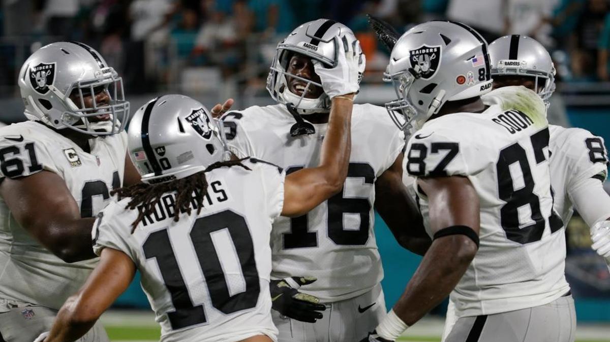 Oakland Raiders center Rodney Hudson (61), wide receiver Seth Roberts (10), and tight end Jared Cook (87), congratulate wide receiver Johnny Holton (16), after Holton scored a touchdown Sunday night.