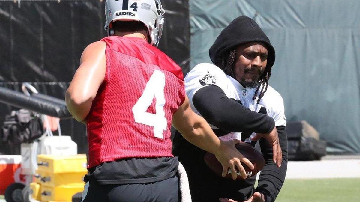 Oakland Raiders quarterback Derek Carr hands off to running back Marshawn Lynch at Monday’s organized team activities.
