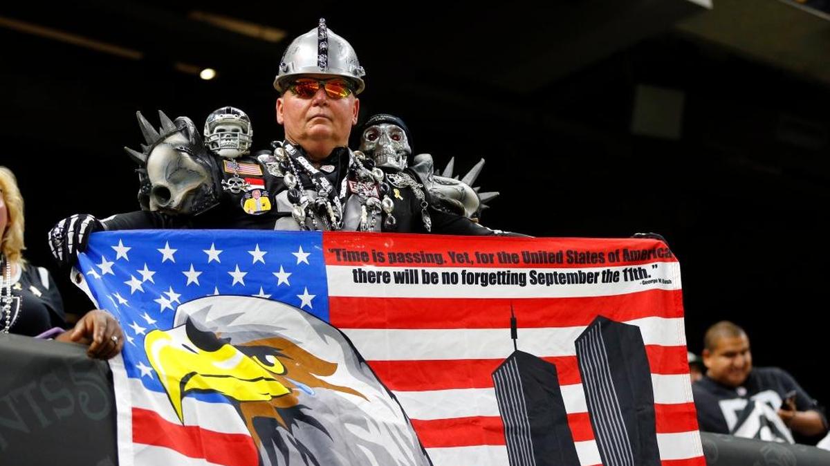 A Raiders fan holds up an American flag in rememberance of 9/11 on Sunday, Sept. 11, 2016, in New Orleans.