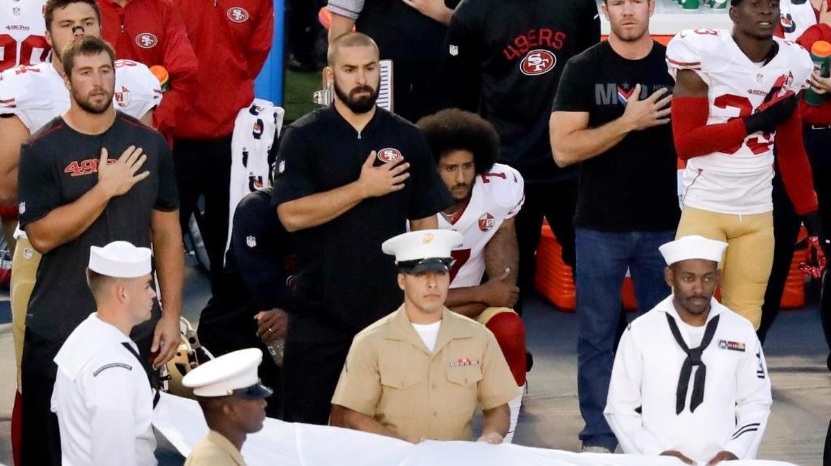 San Francisco quarterback Colin Kaepernick, center, kneels during the national anthem before the team's game against the San Diego Chargers on Thursday, Sept. 1, 2016, in San Diego.