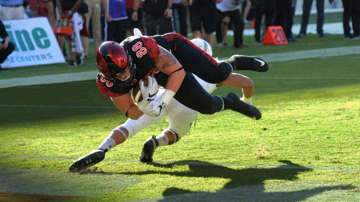 Former Clovis North High standout David Wells scores a touchdown for San Diego State against Hawaii in 2016. Afterward, he pointed toward the sky in tribute to his mom, Annette, who passed away when he was 8. Wells has a tribute tattoo on his left bicep that consists of a cross and roses around the arm.