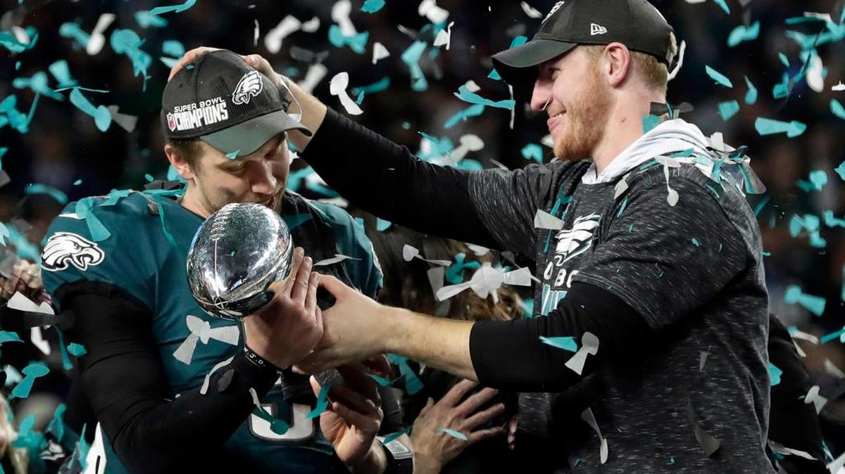 Philadelphia Eagles quarterback Carson Wentz, right, hands the Vincent Lombardi trophy to Nick Foles after the Eagles defeated the New England Patriots 41-33 in the Super Bowl. Wentz was sidelined with a knee injury and Foles stepped in to lead the Eagles.