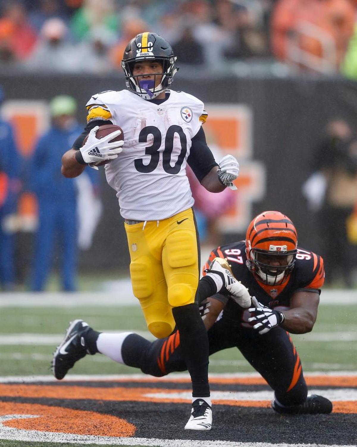 Pittsburgh Steelers running back James Conner (30) runs the ball past Cincinnati Bengals defensive tackle Geno Atkins, left, in the second half of the Steelers 28-21 victory over the Bengals, Sunday, Oct. 14, 2018, in Cincinnati. Conner has rushed for 453 yards and seven touchdowns in the absence of Le’Veon Bell.