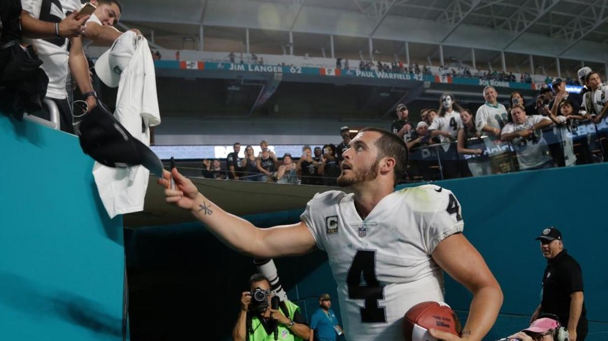 Oakland Raiders quarterback Derek Carr (4) signs autographs at the end of an NFL football game against the Miami Dolphins, Sunday, Nov. 5, 2017, in Miami Gardens, Fla. The Raiders defeated the Dolphins 27-24. (AP Photo/Lynne Sladky)