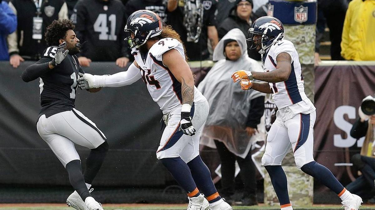 Oakland Raiders wide receiver Michael Crabtree, left, fights with Denver Broncos nose tackle Domata Peko, center, and cornerback Aqib Talib during the first half of an NFL football game in Oakland, Calif., Sunday, Nov. 26, 2017. Crabtree and Talib were ejected.