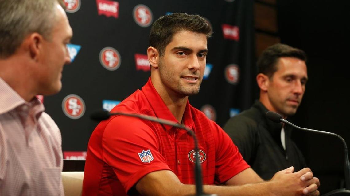 San Francisco 49ers quarterback Jimmy Garoppolo takes questions from the media along with 49ers general manager John Lynch, left, and coach Kyle Shanahan during a news conference in the Levi’s Stadium auditorium in Santa Clara on Tuesday. The 49ers acquired Garoppolo from New England for a second-round draft pick in 2018.