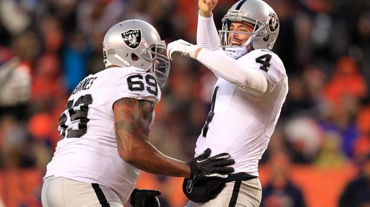 Oakland quarterback Derek Carr celebrates a second-half touchdown pass with tackle Khalif Barnes during the team’s Dec. 13, 2015, game in Denver. The Raiders rallied for a 15-12 victory to keep their playoff hopes alive.