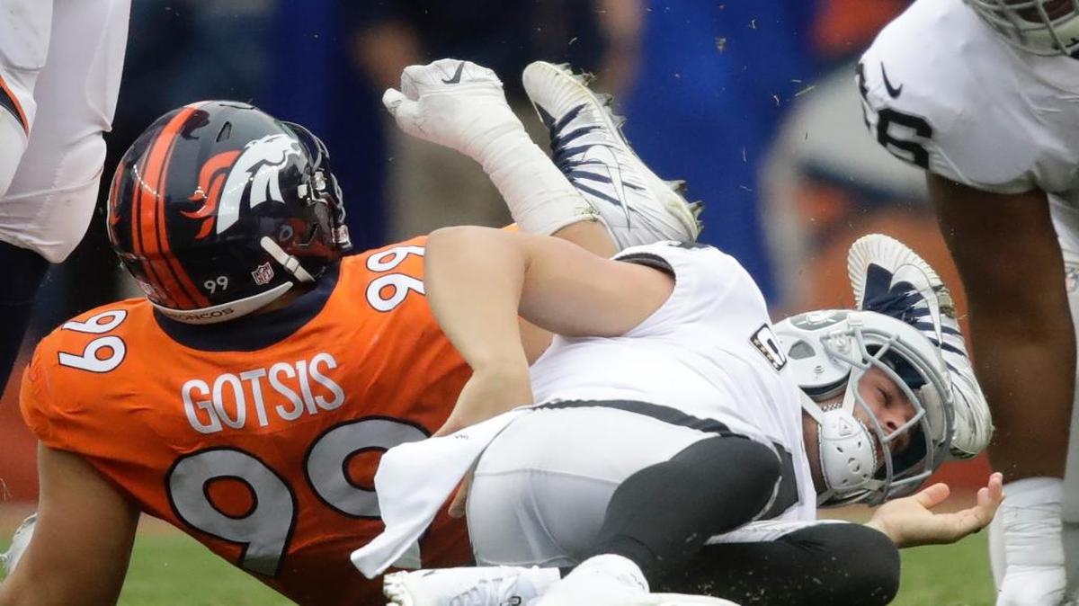 Oakland Raiders quarterback Derek Carr grabs his back after being sacked in Sunday’s game. Carr will be out two to six weeks with the back injury suffered on the play.