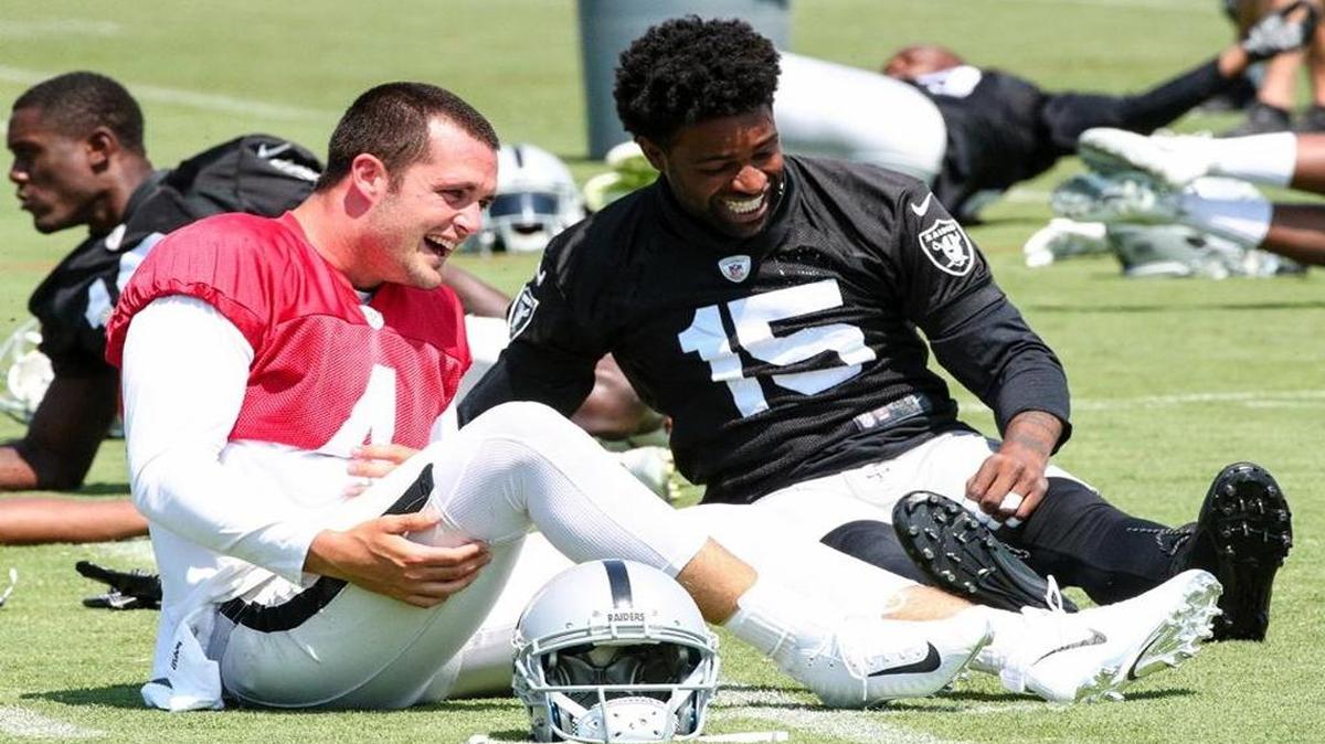 Oakland Raiders quarterback Derek Carr laughs with wide receiver Michael Crabtree at practice this week in Alameda.