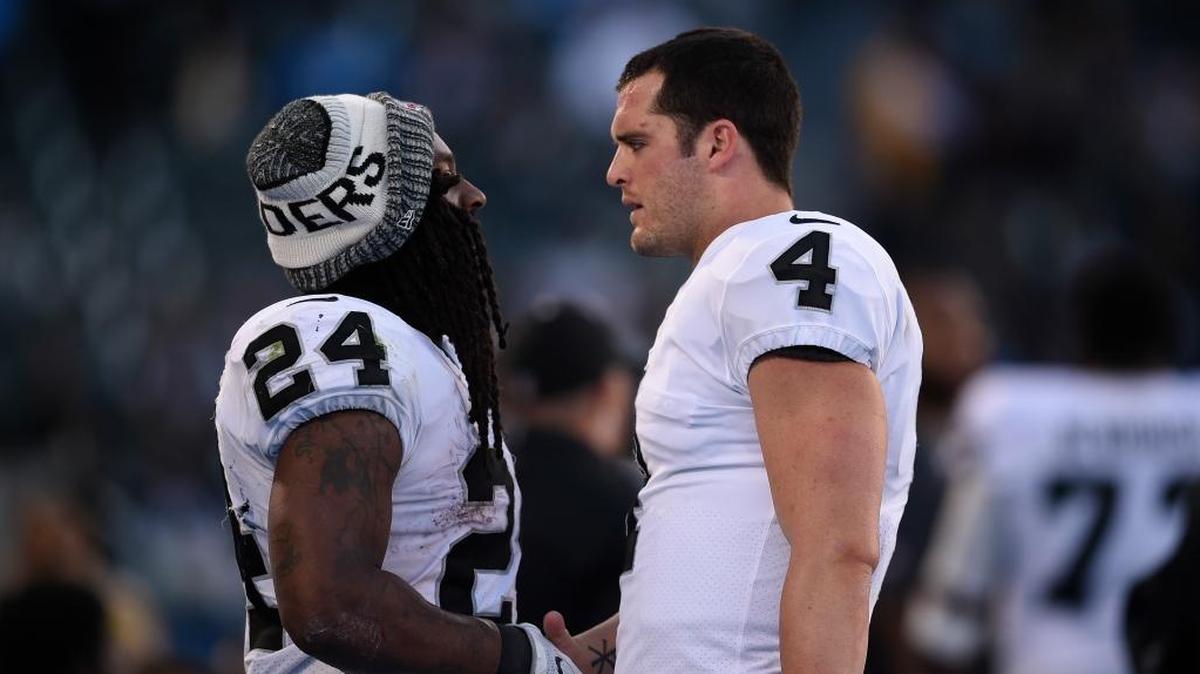 Oakland Raiders running back Marshawn Lynch, left, speaks with quarterback Derek Carr during the second half of the season-finale at the Los Angeles Chargers. Their jerseys rank Nos. 9 (Carr) and 10 (Lynch) among top sellers according to the NFL Players Association.