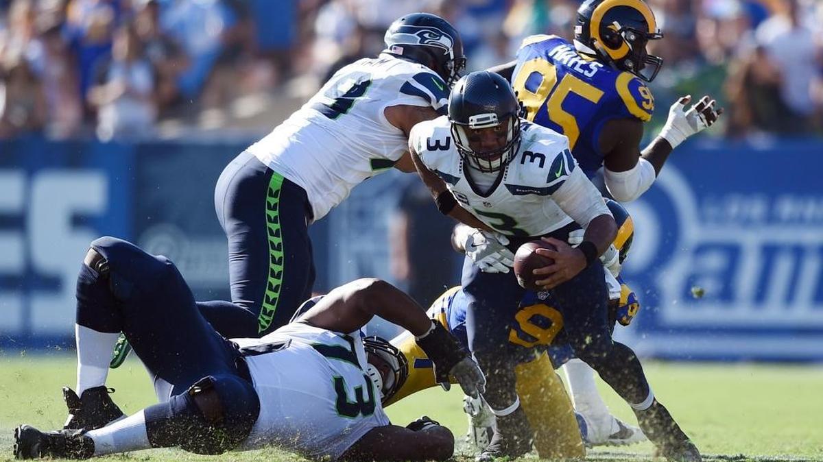 Seattle Seahawks quarterback Russell Wilson (3) scrambles while under pressure by Los Angeles Rams defensive tackle Aaron Donald (99) during the second half of a game at the Los Angeles Memorial Coliseum, Sunday, Sept. 18, 2016, in Los Angeles.