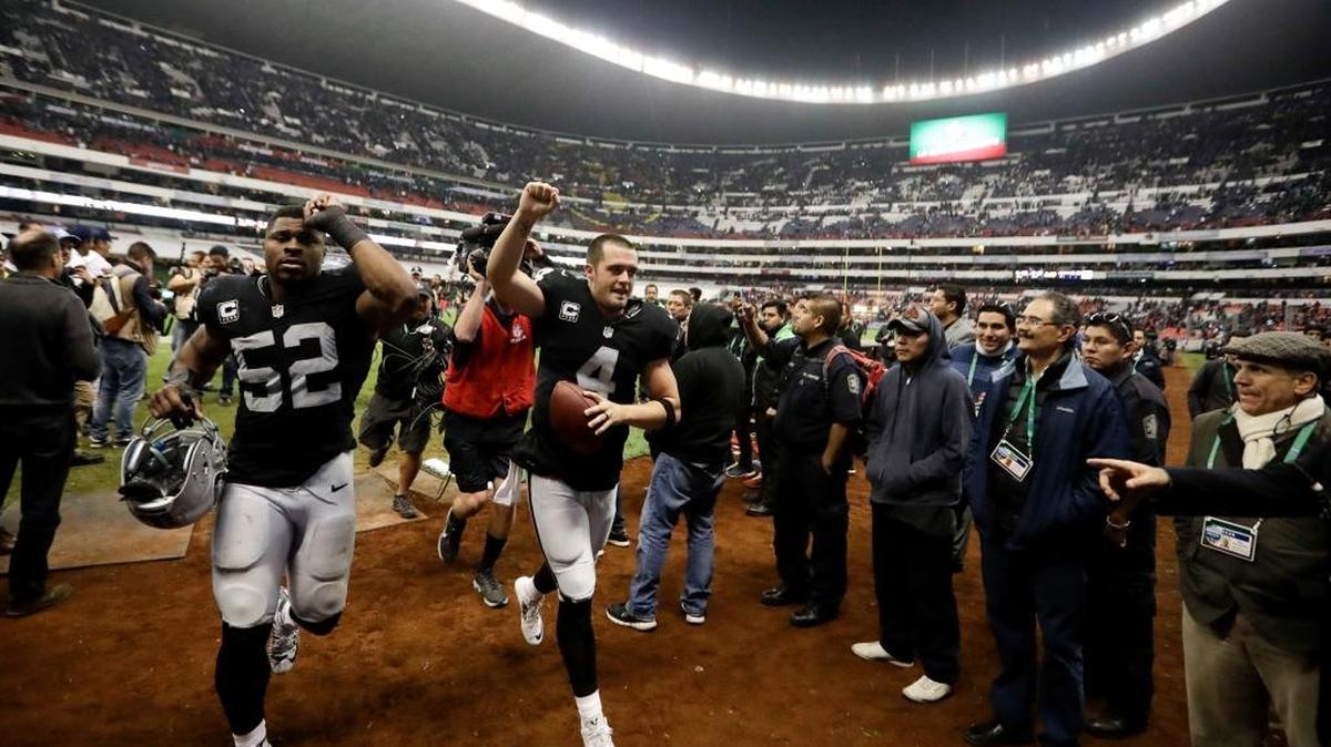 Oakland Raiders quarterback Derek Carr, center, reacts with teammate defensive end Khalil Mack (52) after an NFL game against the Houston Texans Monday, Nov. 21, 2016, in Mexico City. The Raiders will return to Mexico City Nov. 19 against the Super Bowl champions New England Patriots.