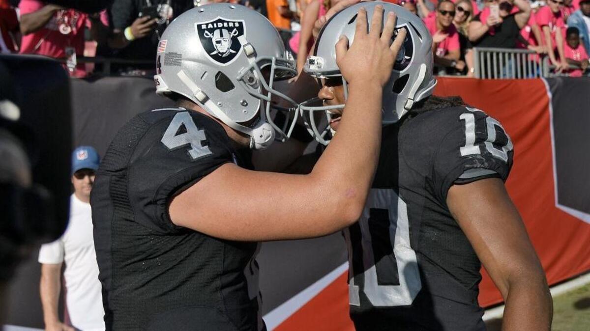 Oakland Raiders quarterback Derek Carr (4) celebrates with wide receiver Seth Roberts (10) after Roberts caught the game-winning 41-yard touchdown pass against the Tampa Bay Buccaneers during overtime in an NFL football game Sunday, Oct. 30, 2016, in Tampa, Fla.