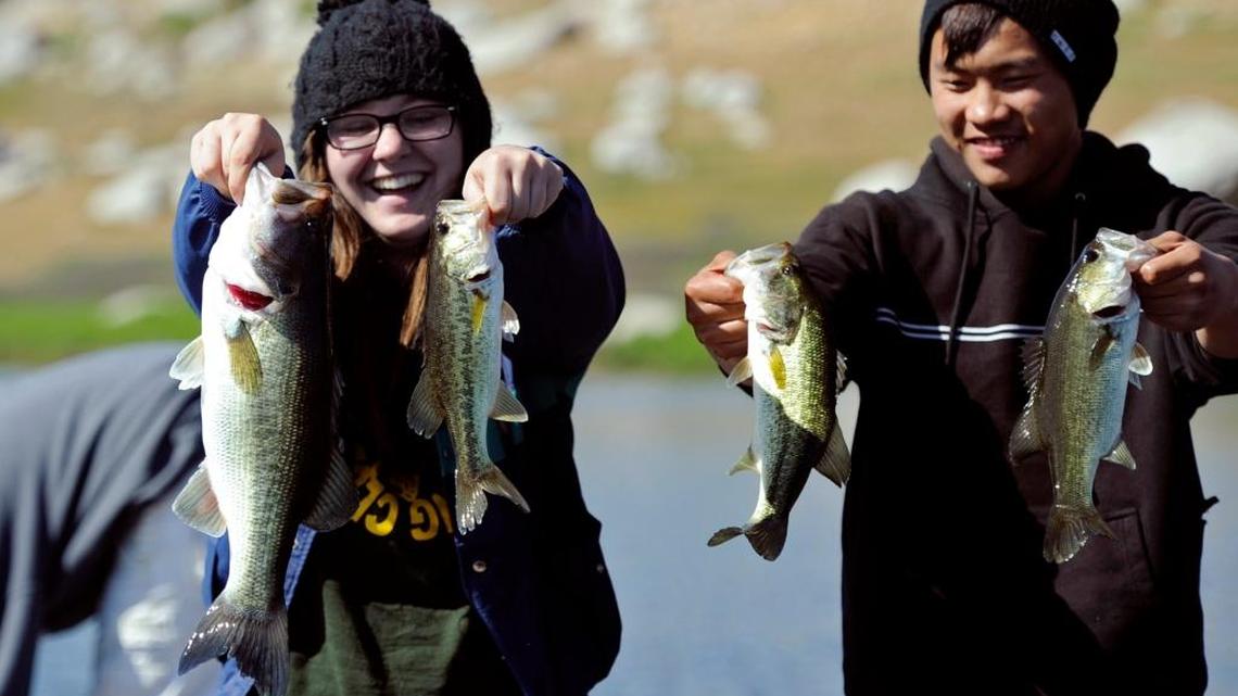 Roosevelt High School Bass Fishing Club president Corrie Williams, left, and Bryce Her, right, hold forth the bass they caught midway through the April Extravaganza bass fishing tournament at Eastman Lake Sunday morning, April 14, 2013.