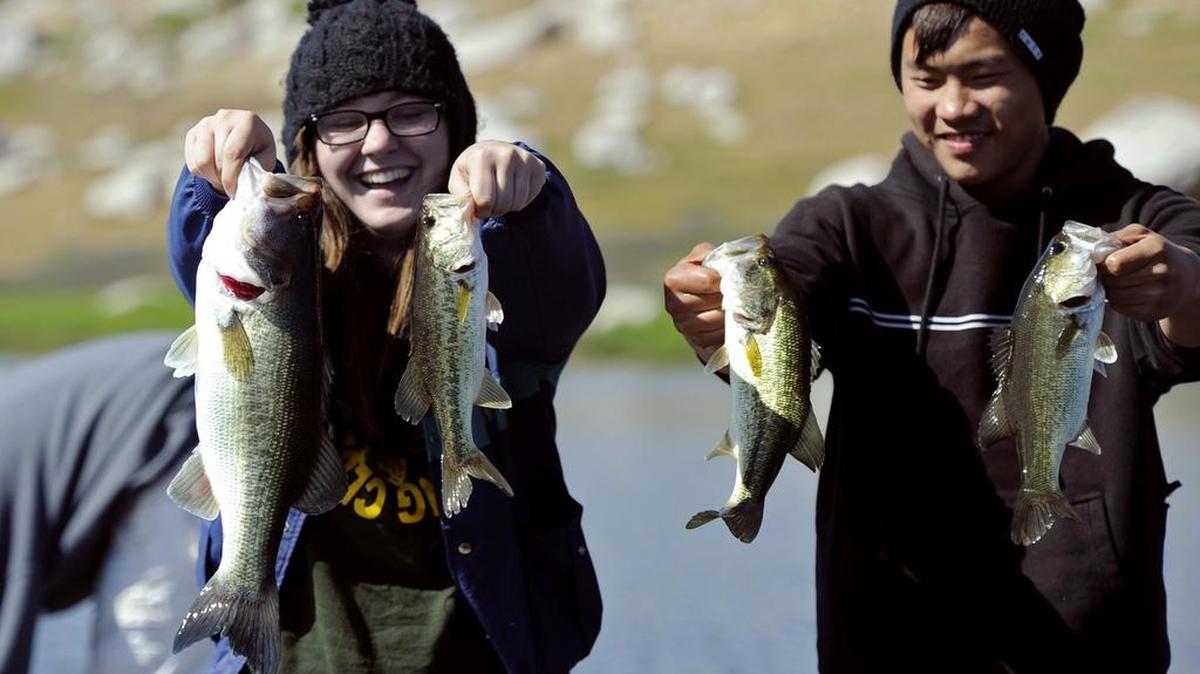 
Roosevelt High School Bass Fishing Club president Corrie Williams, left, and Bryce Her, right, hold forth the bass they caught midway through the April Extravaganza bass fishing tournament at Eastman Lake Sunday morning, April 14, 2013.

