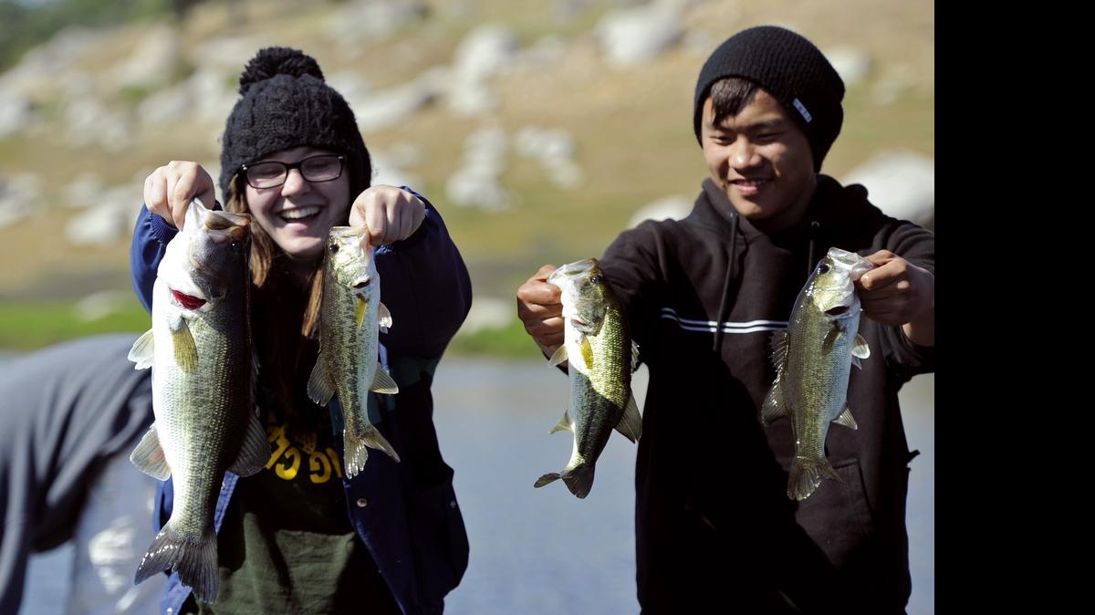 
Roosevelt High School Bass Fishing Club president Corrie Williams, left, and Bryce Her, right, hold forth the bass they caught midway through the April Extravaganza bass fishing tournament at Eastman Lake Sunday morning, April 14, 2013.
