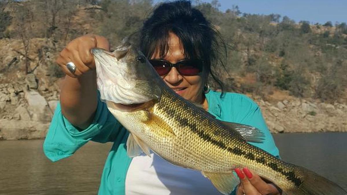 Diana Schmidt shows off her first big spotted bass at Millerton Lake in a photo submitted by husband Randy. “Diana thought she was hung up at 30 feet of water when it peeled the line off the reel,” Schmidt said. “She had to go through a hundred small ones to finally get a great photo fish.”