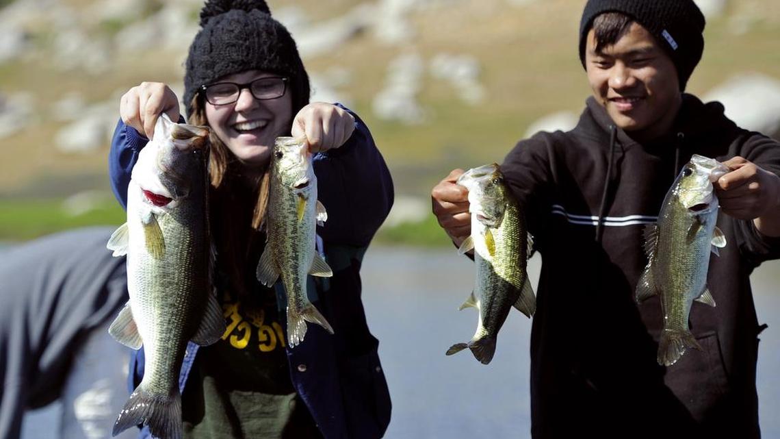 In a 2013 file photo, Roosevelt High School Bass Fishing Club president Corrie Williams, left, and Bryce Her, right, hold forth the bass they caught midway through the April Extravaganza bass fishing tournament at Eastman Lake.