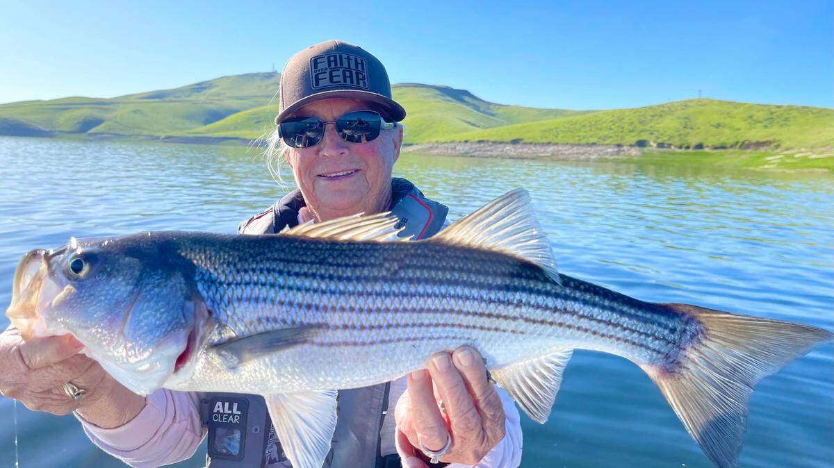 Joann Tacherra of Burrel, California, displays a San Luis striper she caught and released.
