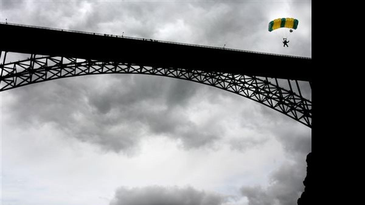 
In this May 28, 2006 file photo, a BASE jumper guides his parachute to the riverbank, after leaping from the Perrine Bridge in Twin Falls, Idaho. The sport has come under increased scrutiny in 2015 due to the recent deaths of several BASE jumpers.
