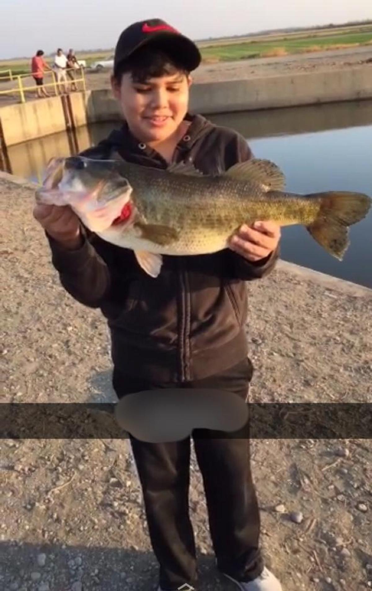 Jair shows off his 22-inch, 8-pound bass caught at Mendota Pool.