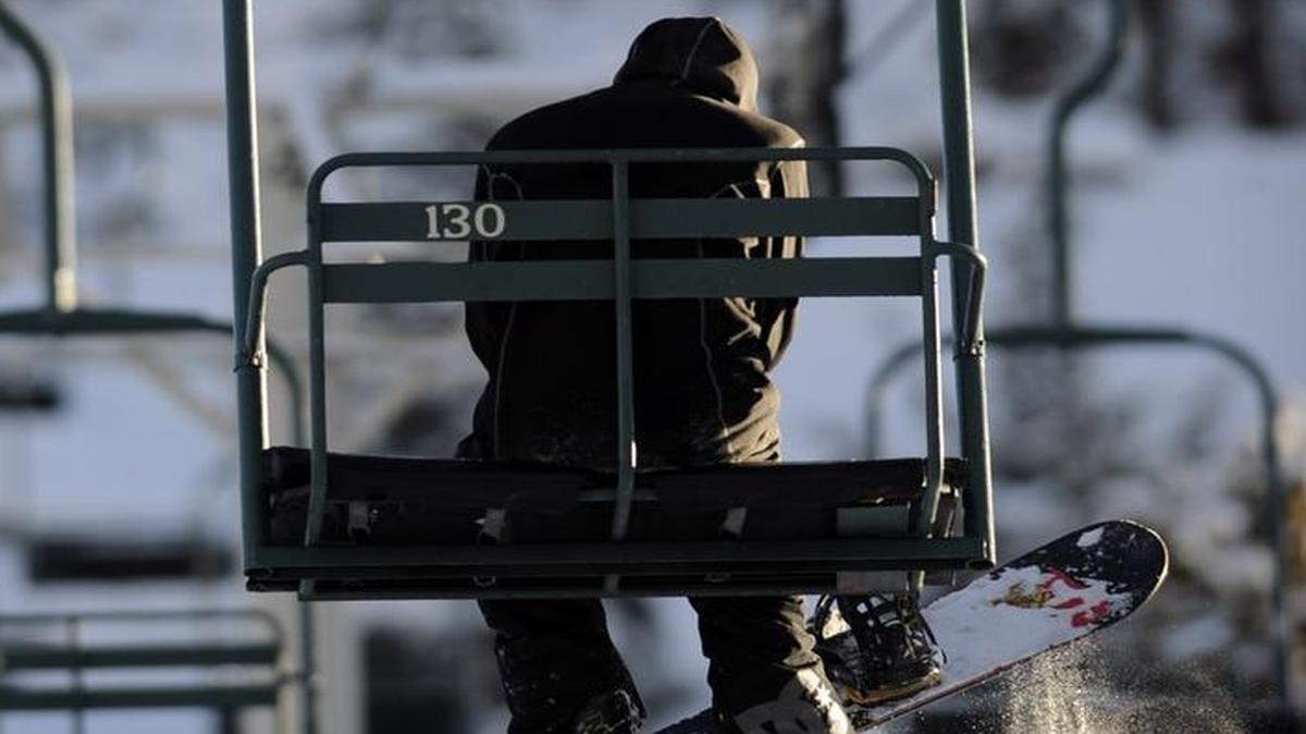 A snowboarder rides Chair 6 up the mountain at China Peak in 2012.