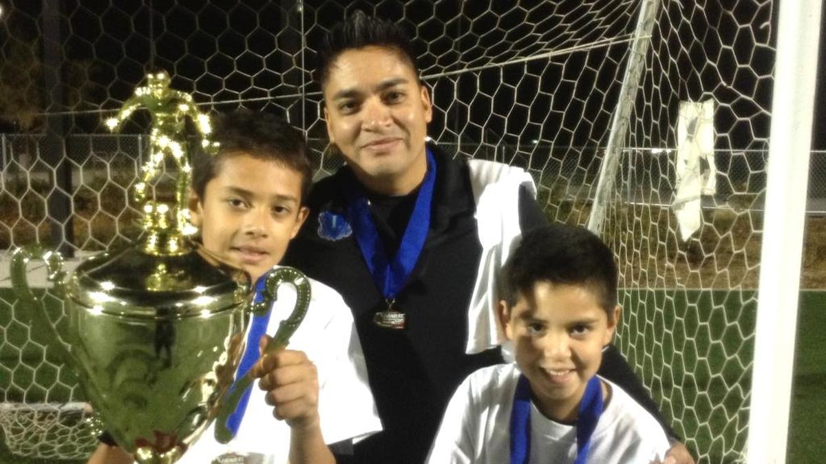 Michael Calvillo with sons Joseph, left, and Christian, right, after winning the 2014 State Founders Cup. Calvillo was one of four finalists for the U.S. Youth Soccer Boys Recreational Coach of the Year award.