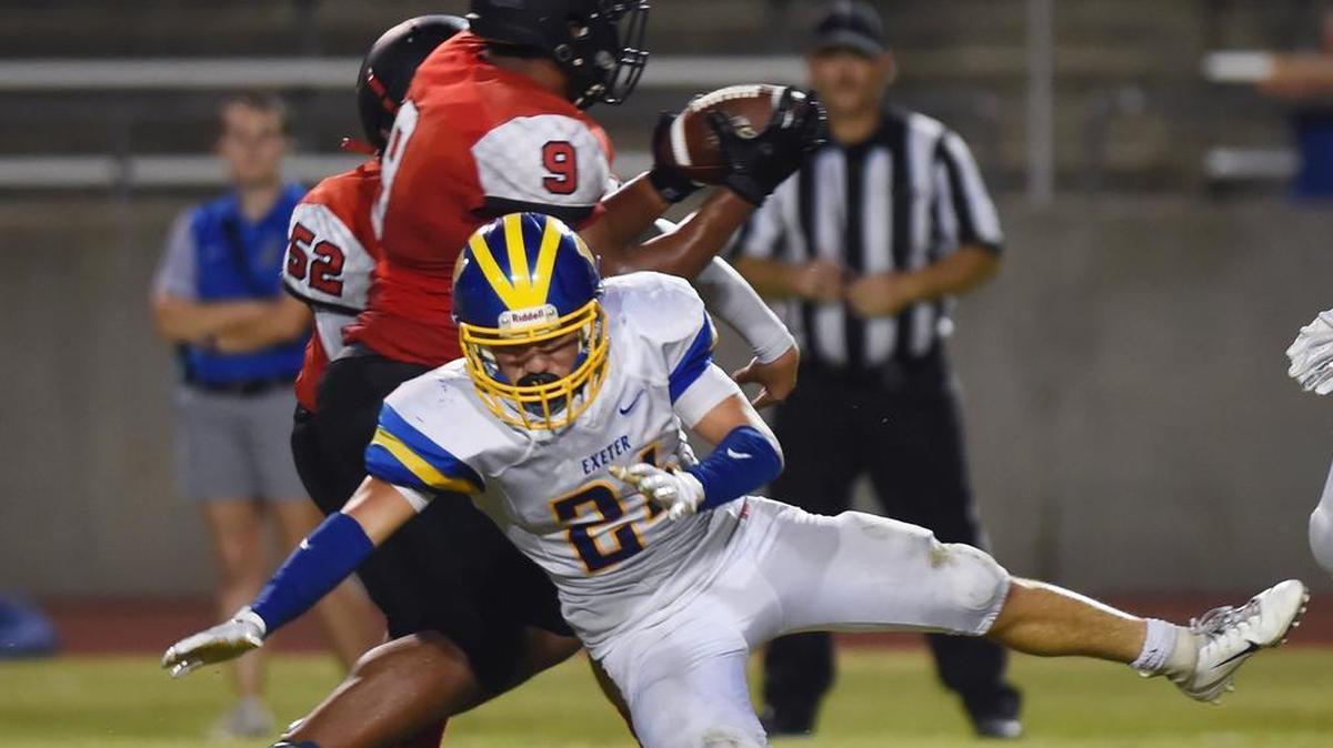 McLane’s John McMichaels, background, grabs a loose ball intended for Exeter’s Nathaniel Heath, foreground, and runs it in for a touchdown Friday, Sept. 7, 2018 in Fresno. McLane led 27-7 at halftime.