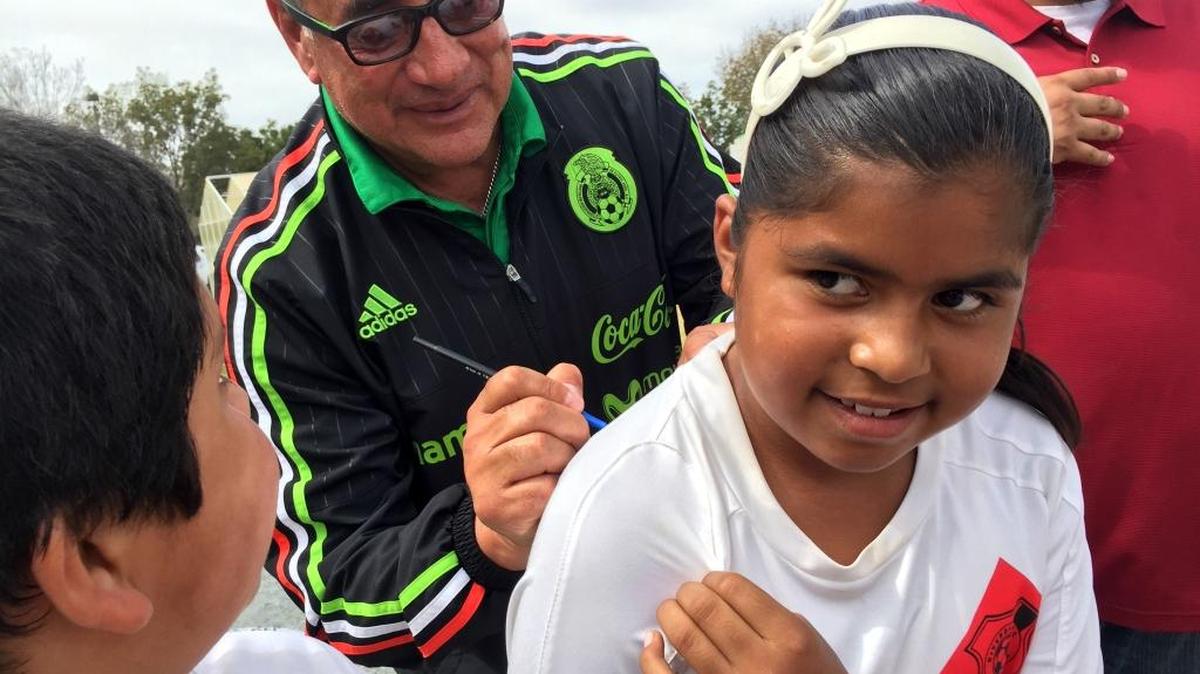 
Nayeli Soriano, 10, holds her Riverdale F.C. team jersey as Mexico women’s national soccer coach Leonardo Cuellar signs his autograph. Cuellar stopped in Riverdale to announce the Pink Cup, his project to recruit the central San Joaquin Valley.
