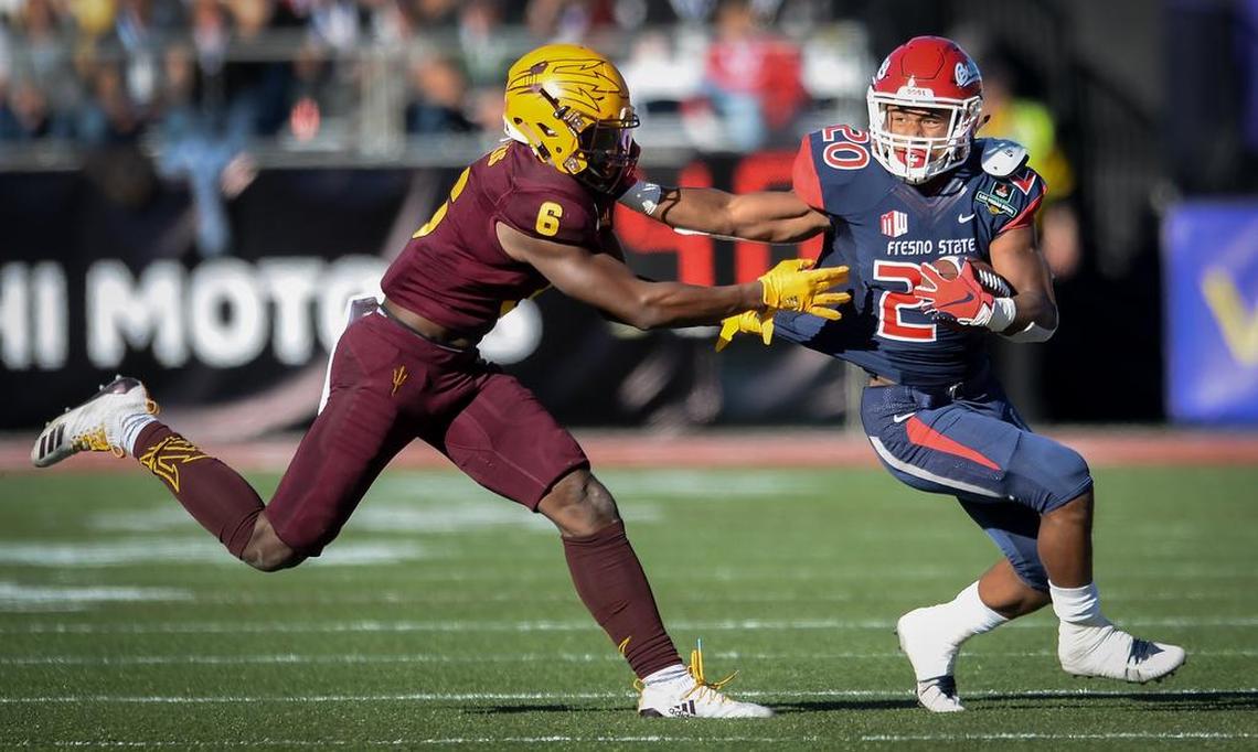 Fresno State’s Ronnie Rivers, right, tries to stiff-arm his way past Arizona State’s Evan Fields on a run during their game at the Mitsubishi Las Vegas Bowl at Sam Boyd Stadium in Las Vegas on Saturday, Dec. 15, 2018.