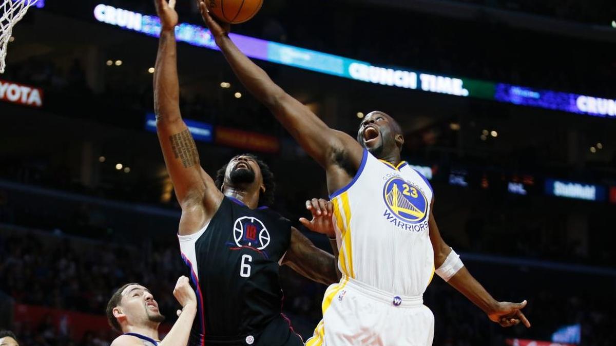 Golden State Warriors forward Draymond Green, right, reaches for a rebound over Los Angeles Clippers center DeAndre Jordan and Warriors guard Klay Thompson, left, on Saturday, Feb. 20, 2016, in Los Angeles.