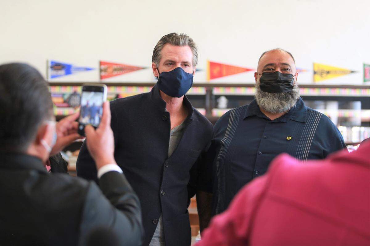 Lupez Chávez, Avenal’s senior code enforcement officer and school board president, right, with Gov. Gavin Newsom, during his visit to a COVID-19 vaccine clinic in Avenal to promote COVID-19 vaccinations and booster shots on Nov. 16, 2021.