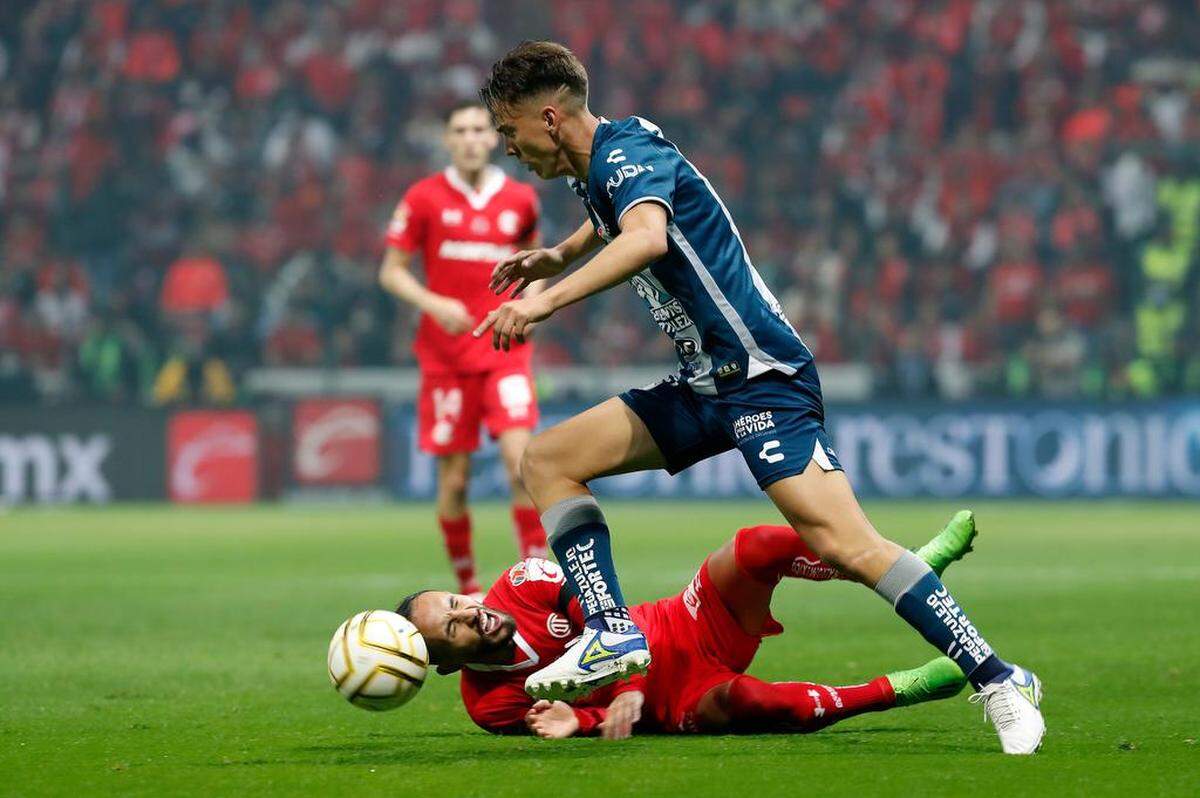 Carlos Guzmán (abajo) del Toluca disputa el balón con Paulino de la Fuente del Pachuca, durante la ida de la final del torneo Apertura 2022 de la Liga MX, en el estadio Nemesio Diez de Toluca, Estado de México.