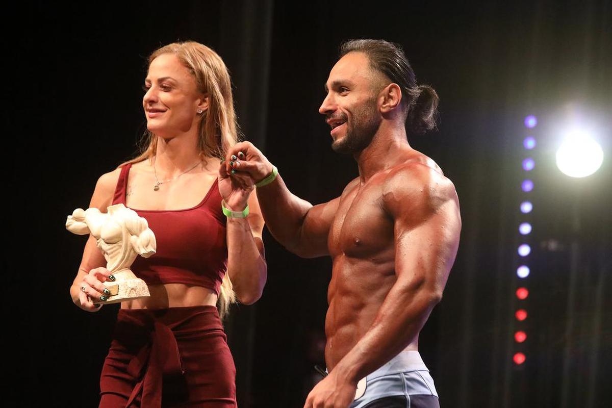 Ashkan Karimi accepts his award from Sydney Taylor after he won the open Physique B Class title at the 2021 NPC Central Califonria Championships on Sept. 18 at the Tower Theatre.