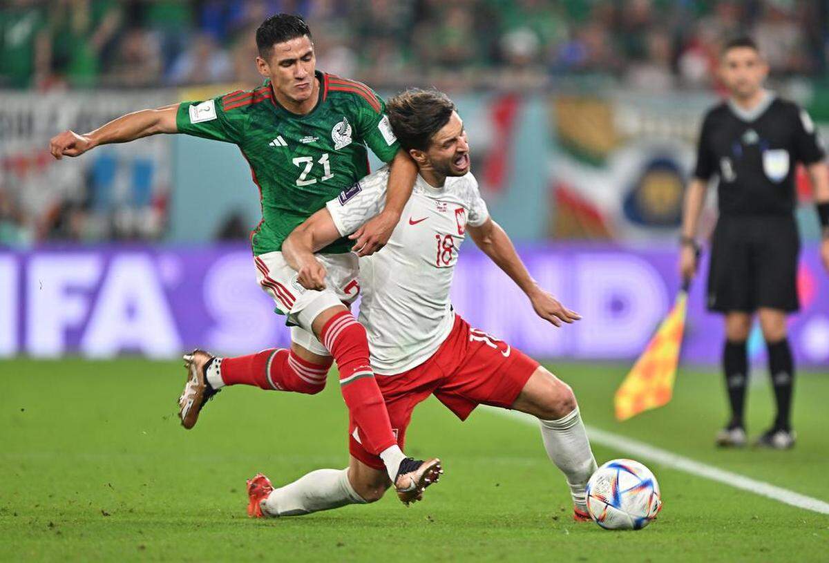 Uriel Antuna of México in action against Bartosz Bereszynski (R) of Poland during the FIFA World Cup 2022 group C soccer match between México and Poland at Stadium 947 in Doha, Qatar