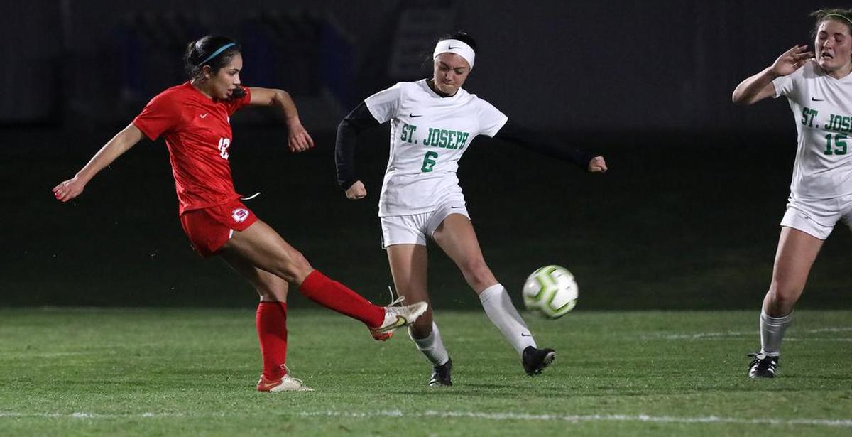 Sanger High senior Karina González takes a shot past the defense of St. Joseph's Trinity Fuller and Reif Madrid in a CIF Central Section Division II quarterfinal match.
